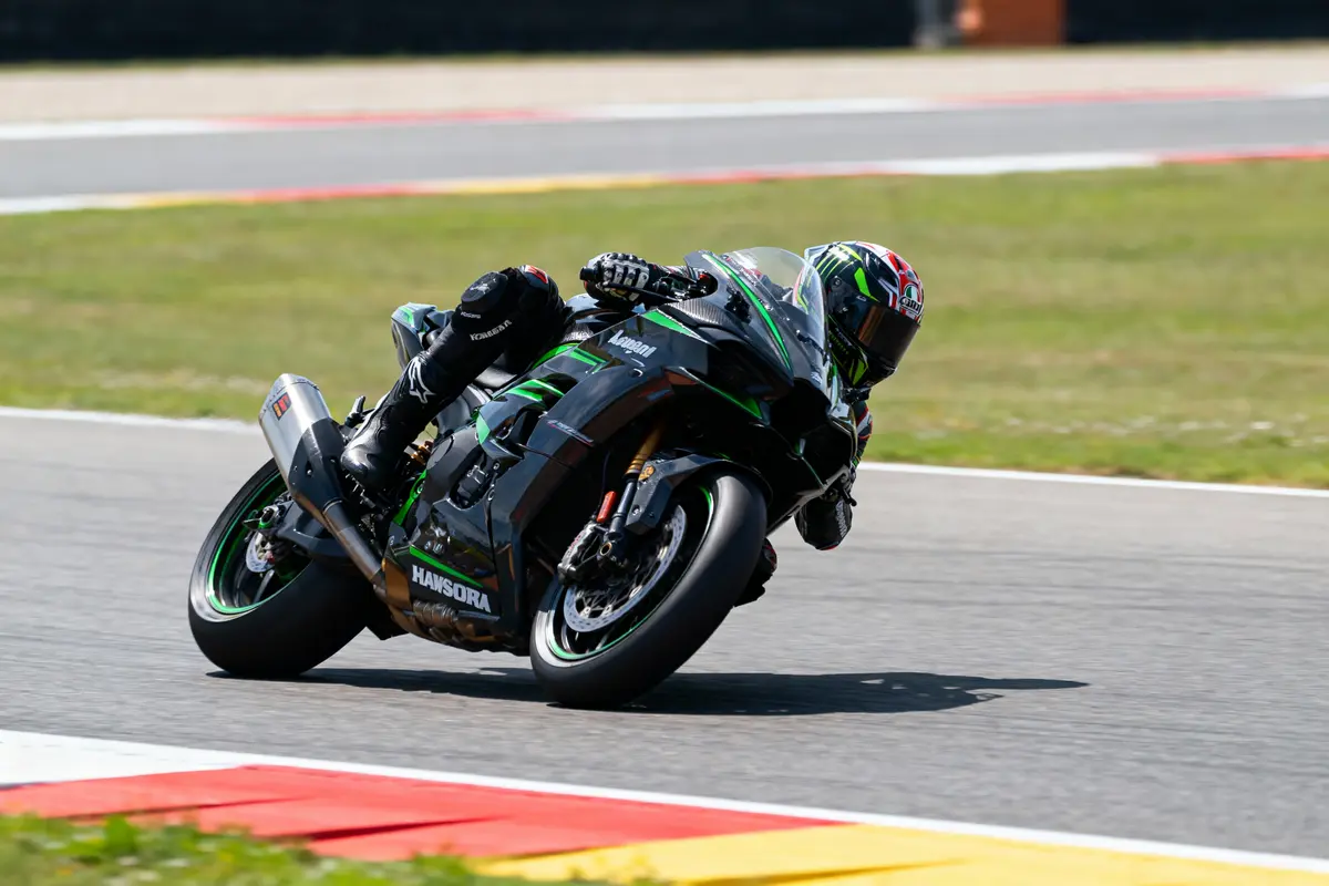 pexels-michal-pech-213601-757318 (1) Pilote de moto en combinaison noire prend un virage sur circuit avec Kawasaki verte et noire.