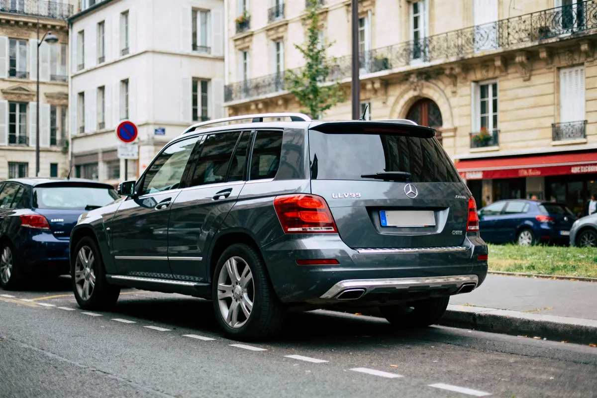 pexels-michal-pech-213601-757318 (1) SUV Mercedes gris garé en ville, devant immeubles haussmanniens, rues calmes, voitures stationnées à proximité.