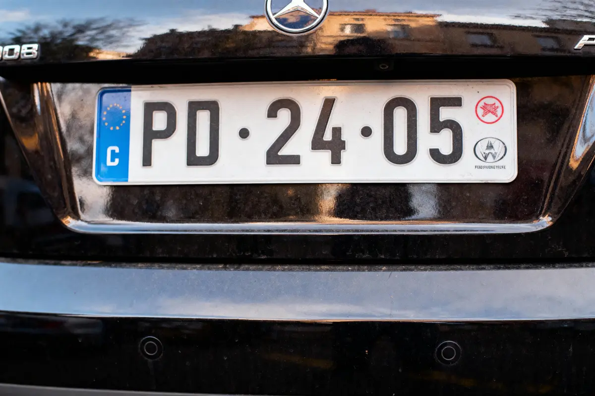 pexels-michal-pech-213601-757318 (1) Plaque d'immatriculation européenne sur voiture Mercedes noire, numéro PD-24-05, avec symboles divers.